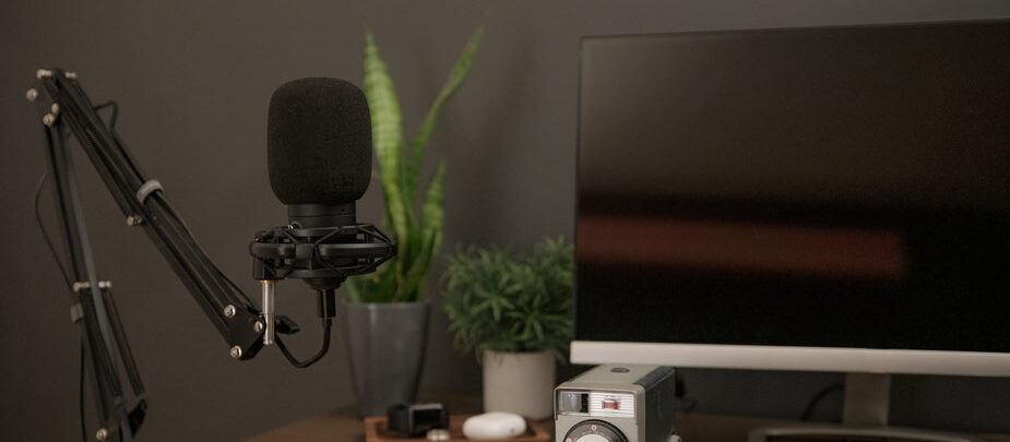 This image has an empty alt attribute; its file name is a-black-microphone-accompanied-by-a-notebook-and-vintage-camera.jpg