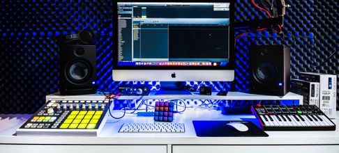A contemporary music studio setup featuring a computer, speakers, and audio equipment.