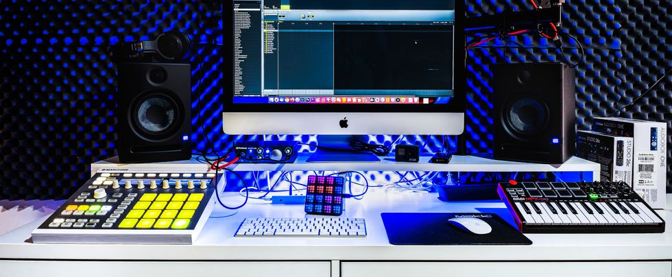 A contemporary music studio setup featuring a computer, speakers, and audio equipment.