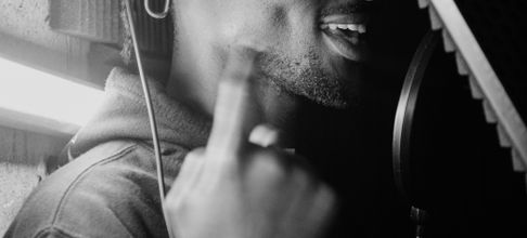 Artistic black and white photo of a male singer in recording studio.