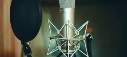Close-up of a studio microphone with pop filter, perfect for recording.