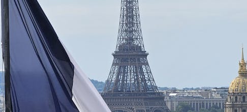 Stunning view of the Eiffel Tower framed by a French flag, capturing the essence of Paris.